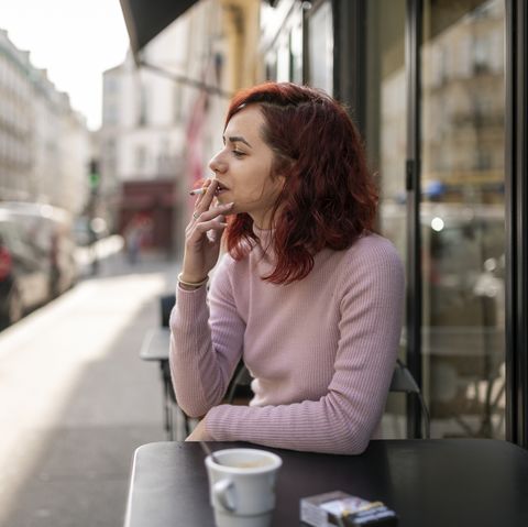 woman smoking in outdoor cafe