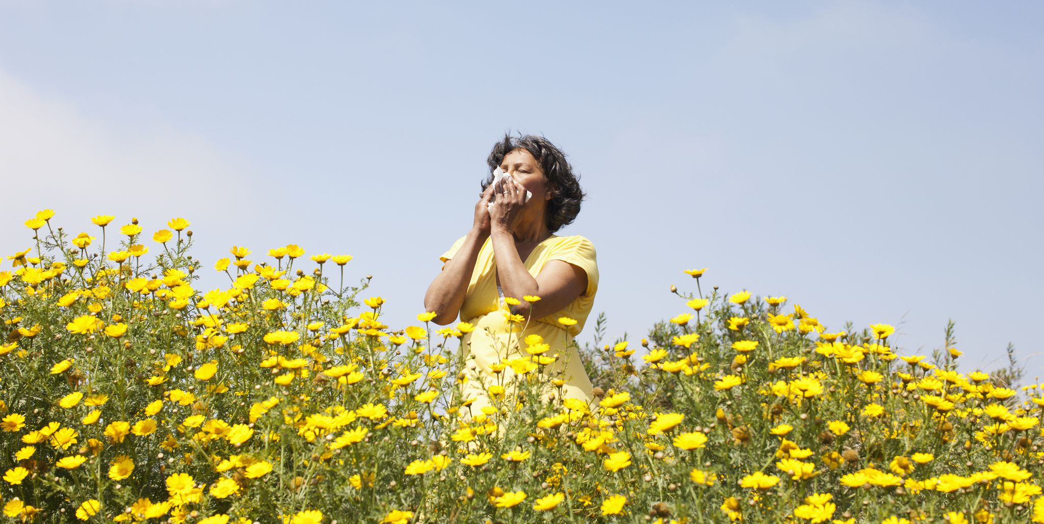 woman sneezing in flowers