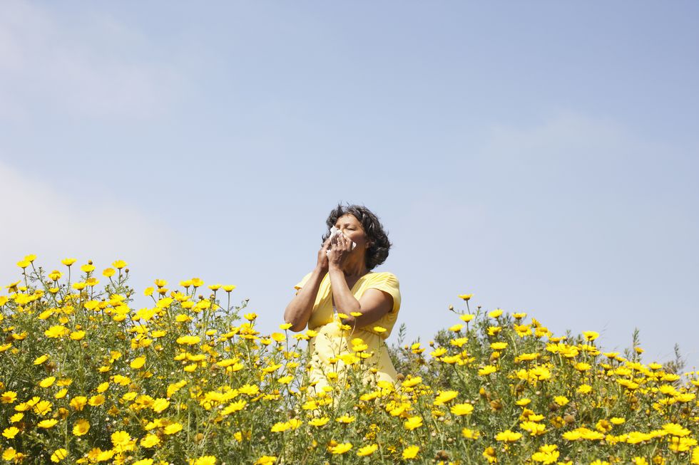 woman sneezing in flowers
