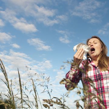 een vrouw niest door hooikoorts