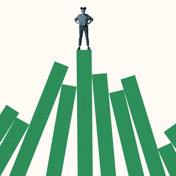 woman standing on top of tall green bar graph