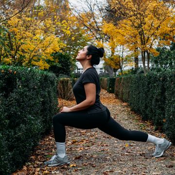 woman stretching in park in a beautiful autumn day