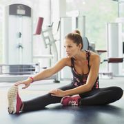 Woman stretching leg at gym
