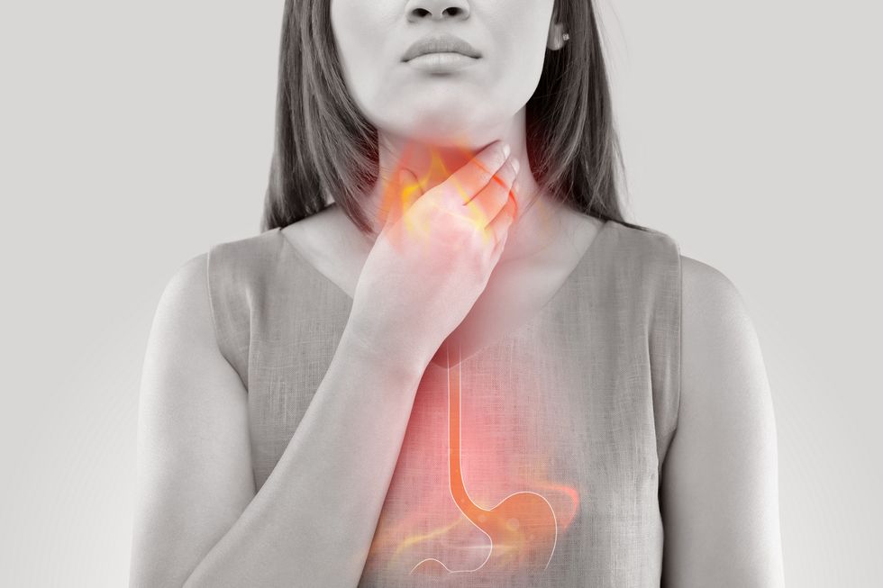 woman suffering from acid reflux or heartburn isolated on white background