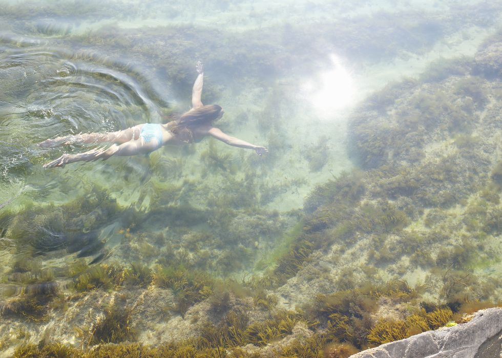 woman swimming in idyllic rock pool