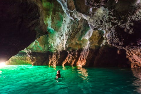 Woman swimming in Koh Mook's Emerald Cave, Thailand woman swimming in koh mook's emerald cave, thailand