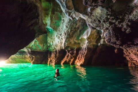 woman swimming in koh mook's emerald cave, thailand