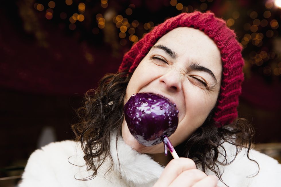 woman taking a bite of candied apple