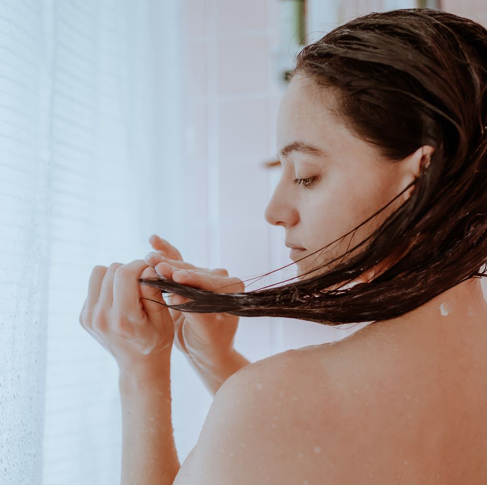 woman taking a shower and washing her hair at home