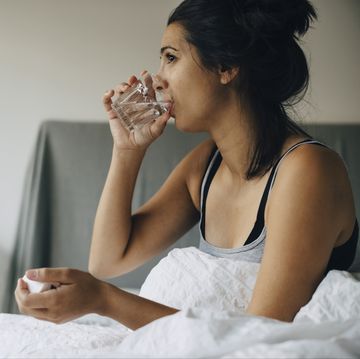vrouw met glas water op bed