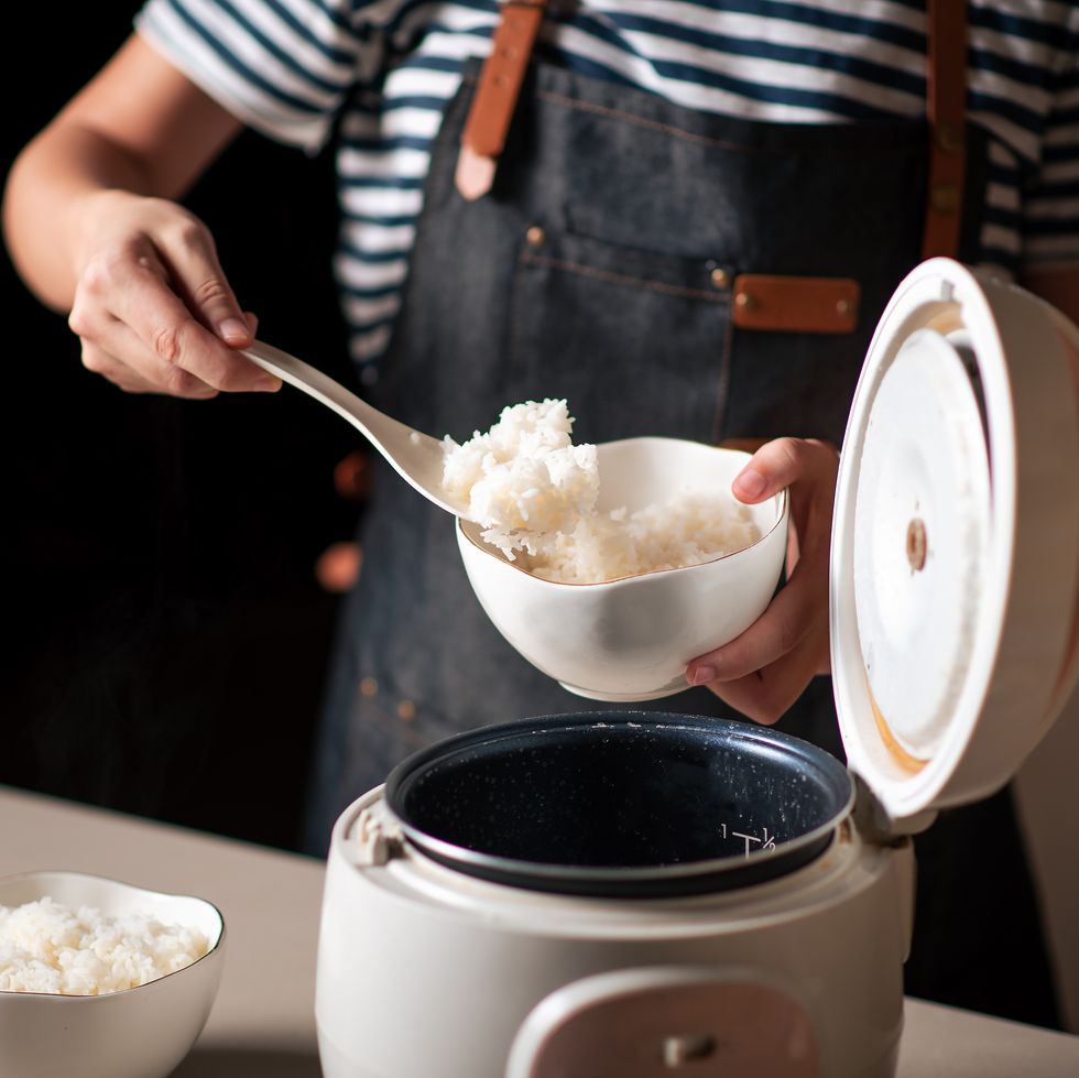 https://hips.hearstapps.com/hmg-prod/images/woman-taking-out-and-serving-fresh-boiled-rice-from-royalty-free-image-1651258733.jpg?crop=0.668xw:1.00xh;0.209xw,0&resize=980:*