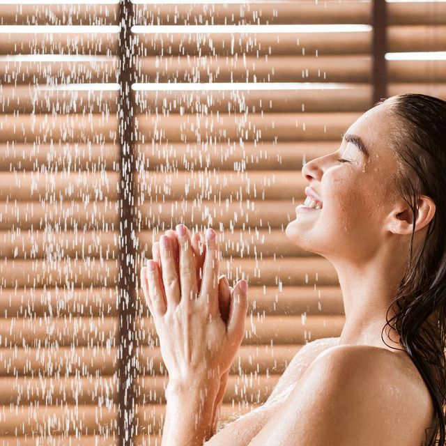 woman taking shower enjoying water splashing on her