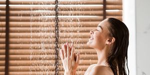 woman taking shower enjoying water splashing on her