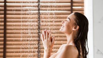 woman taking shower enjoying water splashing on her