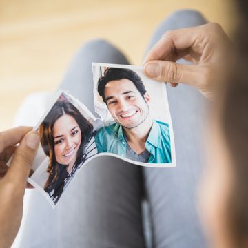 woman tearing picture of herself with ex boyfriend