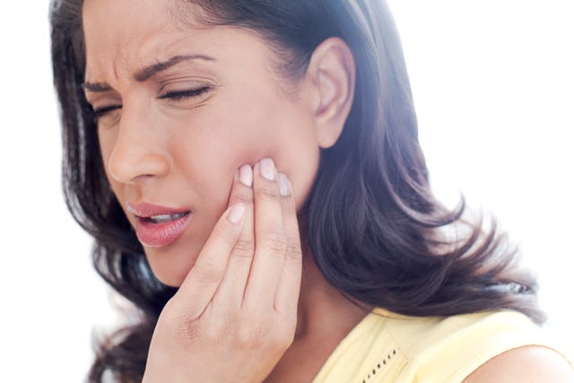 woman touching her cheek in pain