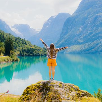 woman tourist admiring summer with scenic view of lake lovatnet in norway