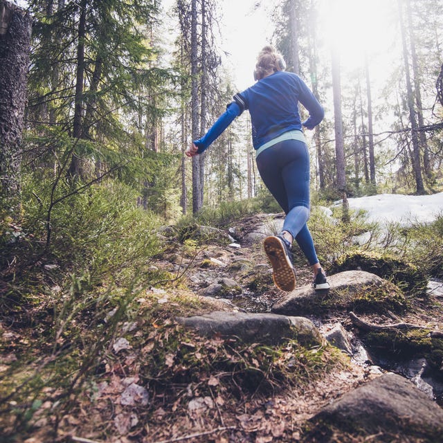 woman trail runner running in forest