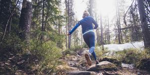 woman trail runner running in forest