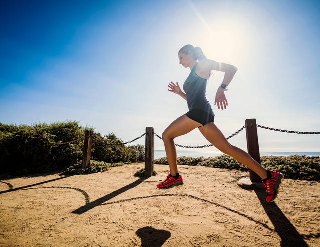 woman trail running activities at beach