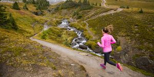 A woman trail running in the mountains.