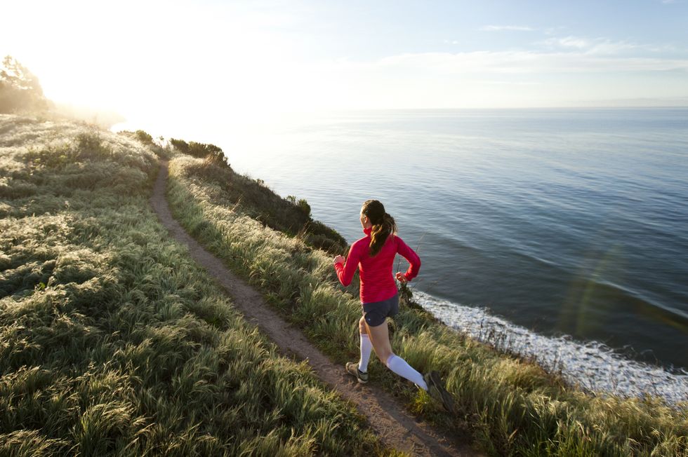 woman trail running near the ocean