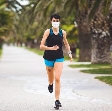 Woman training outdoors wearing healthcare mask during social distancing on lockdown woman training outdoors wearing healthcare mask during social distancing on lockdown