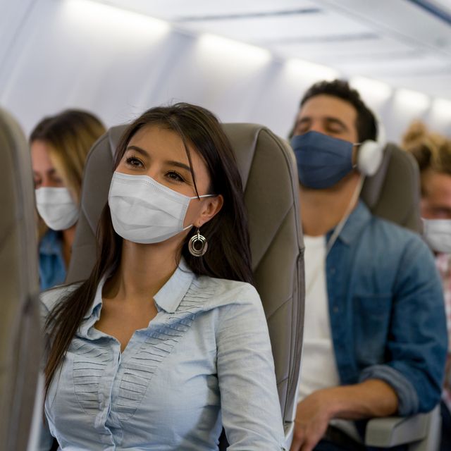 woman traveling by plane wearing a facemask