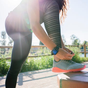 woman tying her shoe before workout