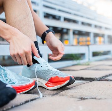 woman tying her shoe before workout