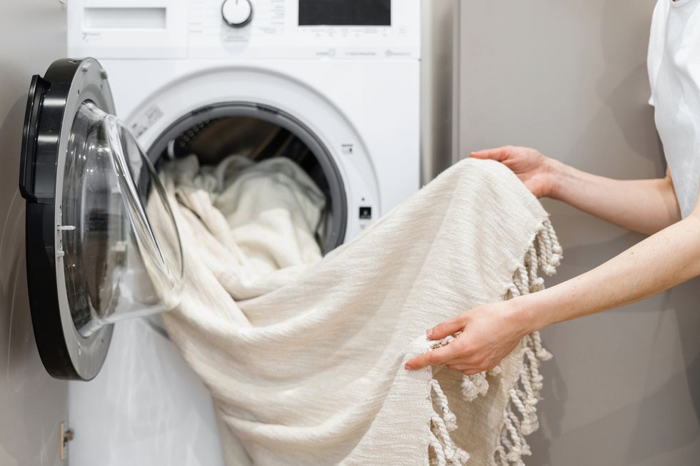 ドラム式洗濯乾燥機からブランケットを取り出す女性