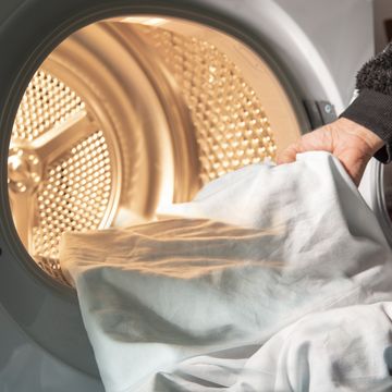 woman uses dryer to dry laundry