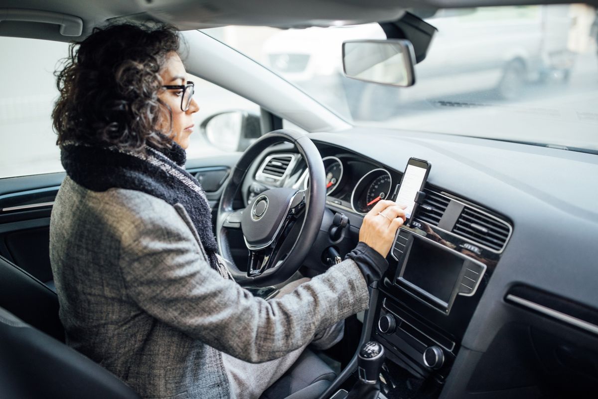 woman uses navigation on her mobile phone in the car