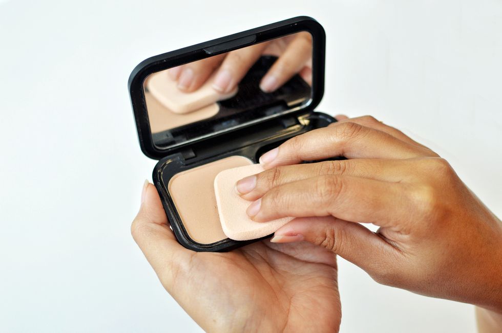 Make-up: woman using compact face powder
