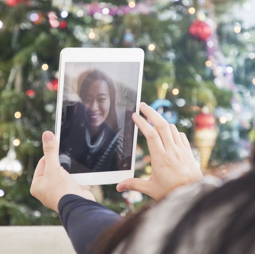 woman using digital tablet for video call at christmas