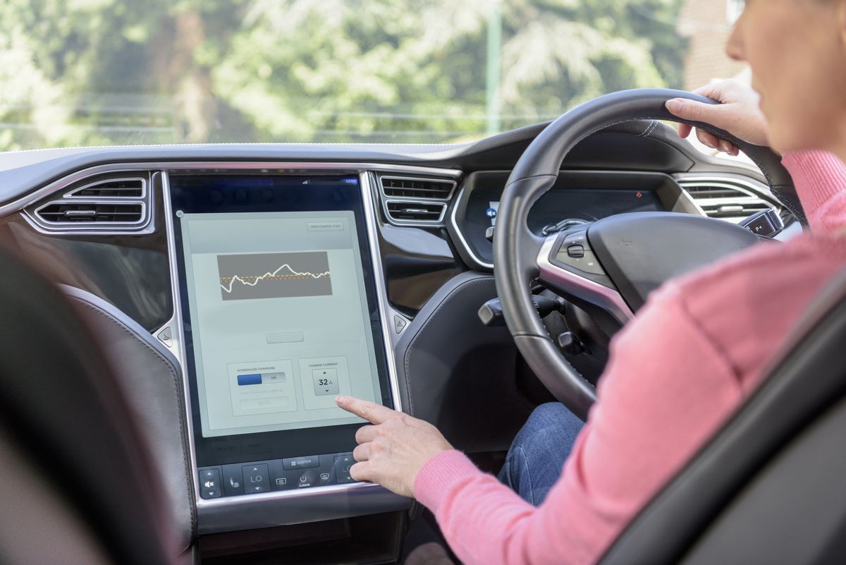 Woman using graphical display in electric car
