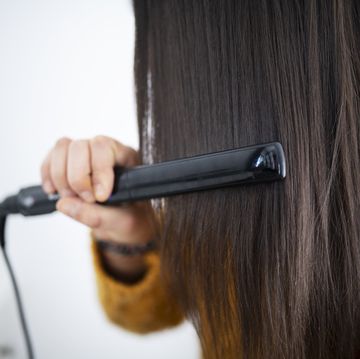 woman using hair straightener