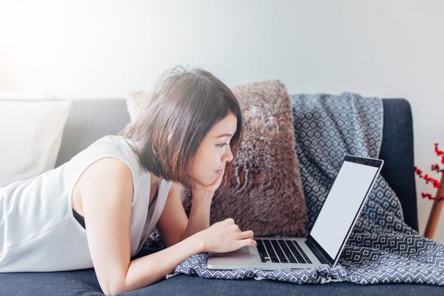 Woman using laptop on sofa