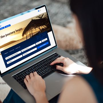 woman using laptop to book flight tickets and plan holiday