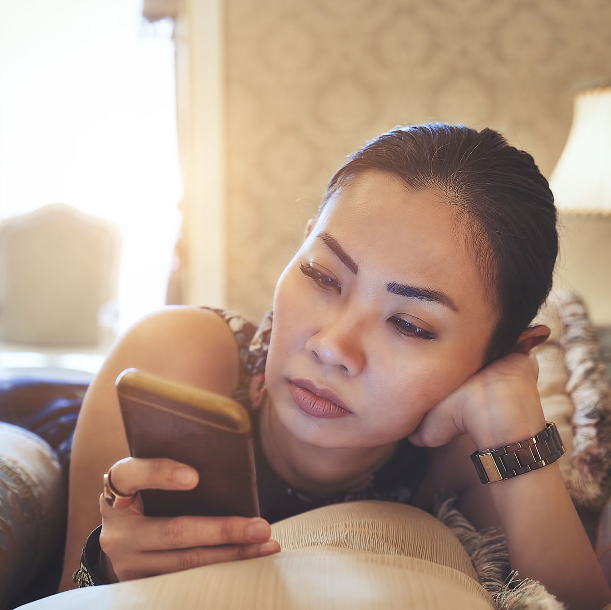 woman using mobile phone in bed