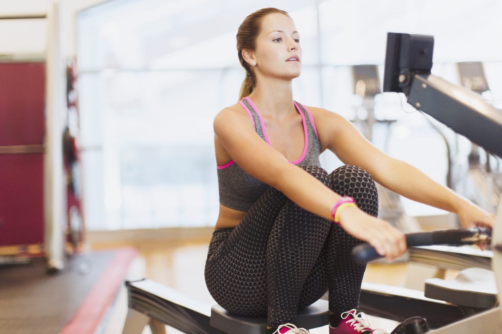 Woman using rowing machine at gym