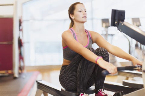 Woman using rowing machine at gym