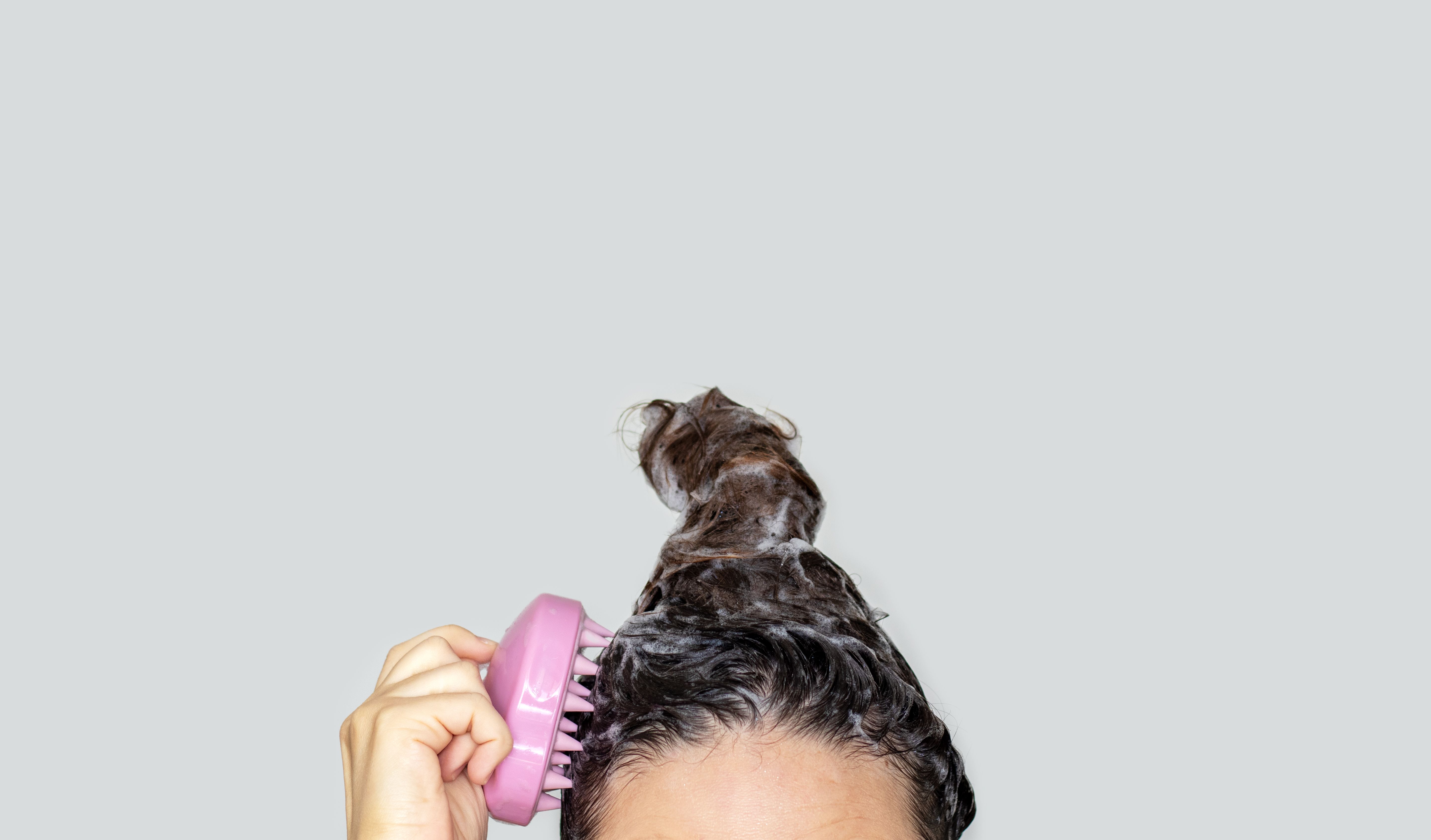 https://hips.hearstapps.com/hmg-prod/images/woman-using-silicone-pink-shampoo-brush-for-scalp-royalty-free-image-1679942200.jpg