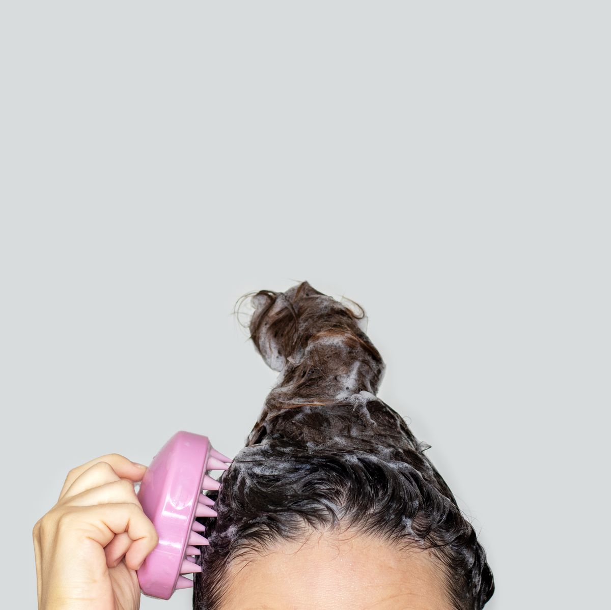 https://hips.hearstapps.com/hmg-prod/images/woman-using-silicone-pink-shampoo-brush-for-scalp-royalty-free-image-1679942200.jpg?crop=0.588xw:1.00xh;0.207xw,0&resize=1200:*
