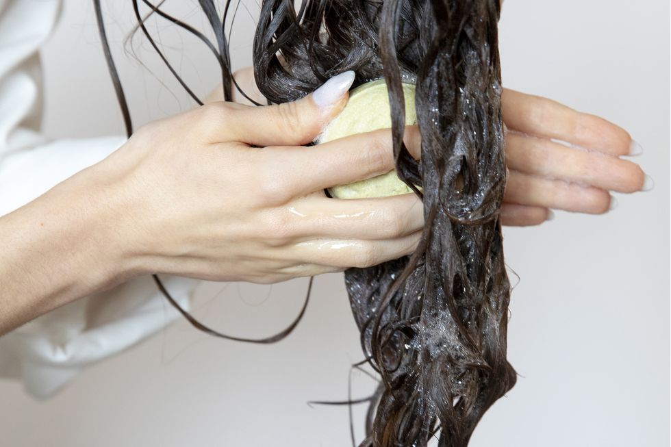woman using solid soap washing hair with shampoo bar