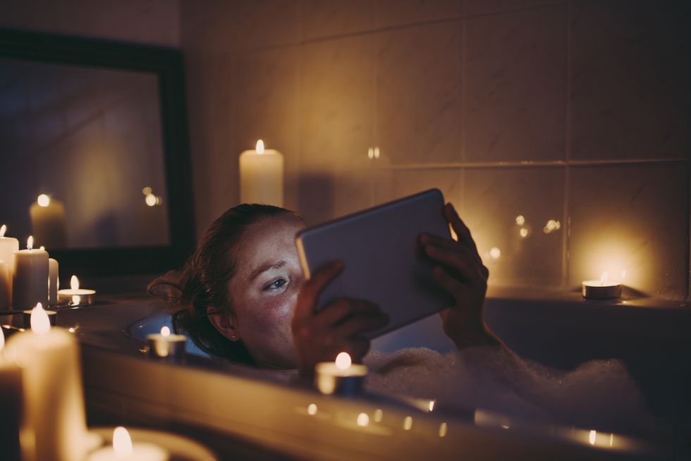 woman using tablet pc in bathtub