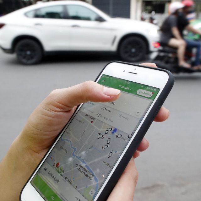 Woman using the Grab app on an Apple iPhone 6 Ho Chi Minh City Vietnam