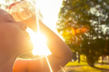 Woman using water bottle to cool down.