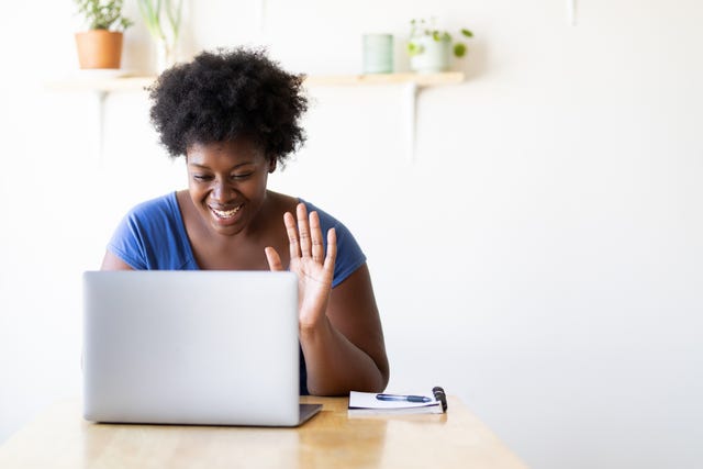 woman video calling using a laptop at home