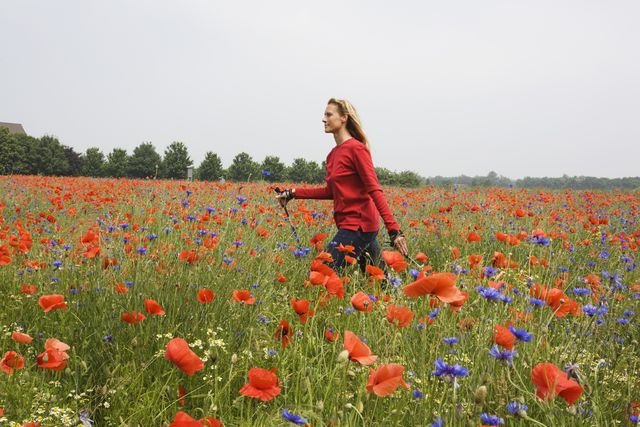 woman walking across poppy field